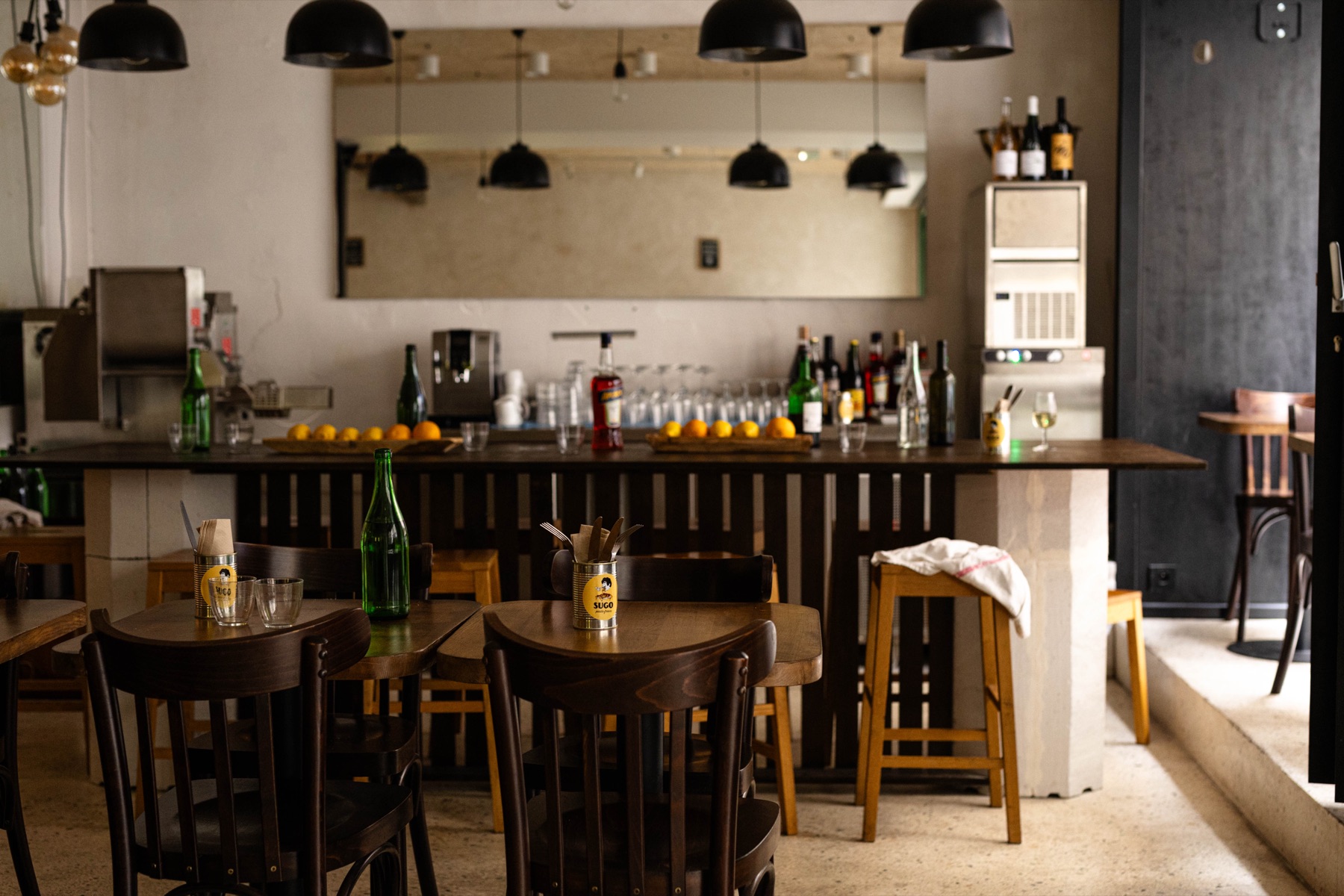 La salle de SUGO Saint-Augustin : comptoir, chaises bistrot et tables en bois